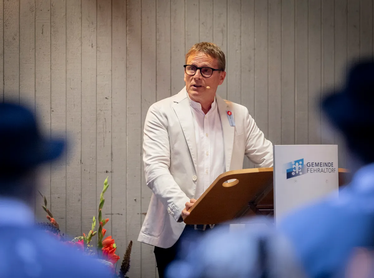 National- und Kantonsrat Martin Hübscher (SVP) hielt in Fehraltorf eine Ansprache. Martin Hübscher steht an einem Rednerpult.